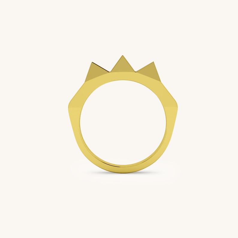 K&ouml;nnte beinhalten: Ein goldener Ring mit einem spitzen, kronenartigen Design.