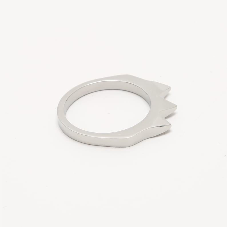 K&ouml;nnte beinhalten: Ein silberner Ring mit einem spitzen, kronenartigen Design.
