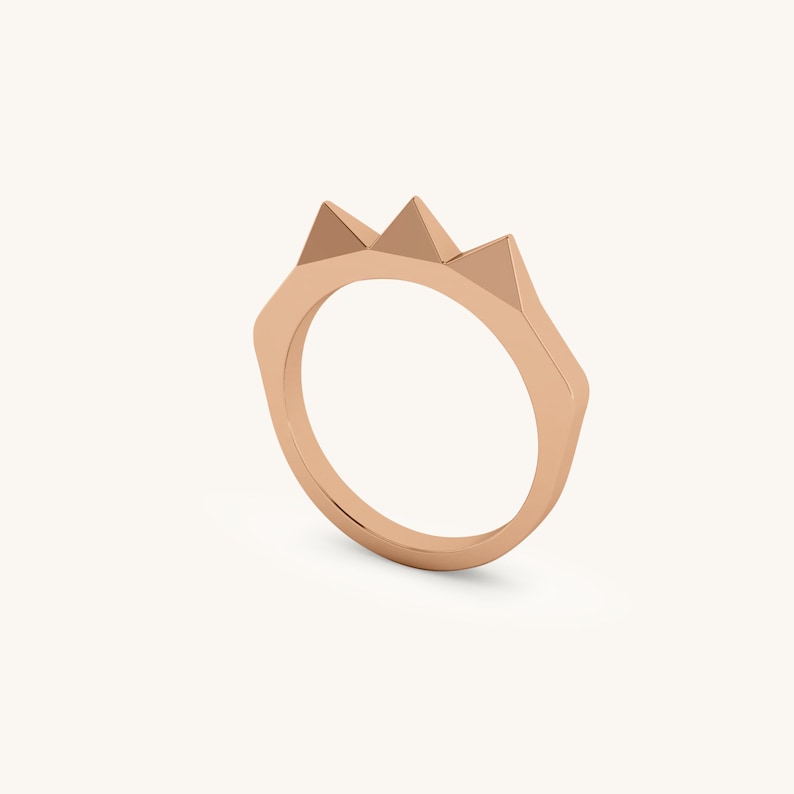 K&ouml;nnte beinhalten: Ein Ring aus Ros&eacute;gold mit drei dreieckigen Spitzen auf der Oberseite.