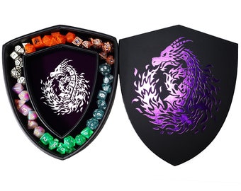 May include: A black shield-shaped dice tray with a purple and white dragon design. The tray is open to reveal a set of colorful dice inside.