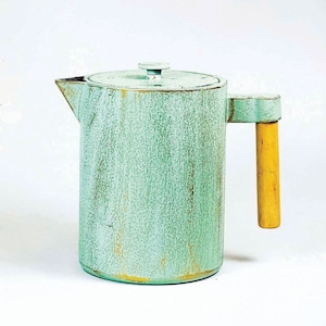 Op de afbeelding: Een lichtgroene metalen theepot met een verweerde afwerking en een houten handvat.