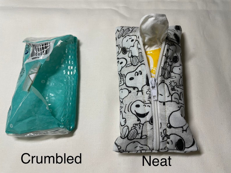 Op de afbeelding: Twee tissueboxen, een gekreukeld en een netjes. De nette doos is wit met een zwart-wit patroon van Snoopy-figuren. De doos heeft een ritssluiting.
