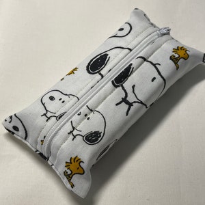 Pu&ograve; includere: Copertura per scatola di fazzoletti in tessuto bianco con chiusura a zip. La copertura presenta un motivo ripetuto di cani di cartoni animati in bianco e nero e uccelli gialli.