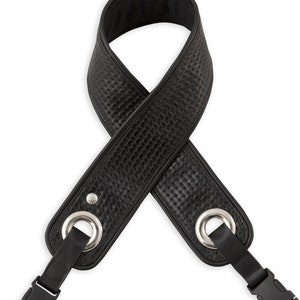 May include: Black leather camera strap with silver metal rings and black plastic clips.