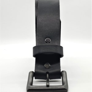 May include: A black leather belt with a gunmetal buckle. The belt is made of thick, durable leather and features a classic design. The buckle is square and has a matte finish.