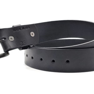 May include: Black leather belt with a gunmetal buckle. The belt is marked "MADE IN USA" and size 36. The belt has several holes for adjustment.
