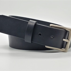 May include: A black leather belt with a silver buckle. The belt is folded in half and the buckle is facing the camera.