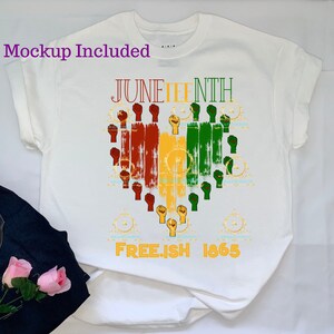 Puede incluir: Camiseta blanca con un diseño gráfico de un corazón hecho de puños levantados en rojo, amarillo y verde. El texto "Juneteenth" está por encima del corazón y "Free.ish 1865" está por debajo del corazón.