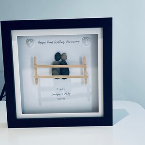 May include: A framed pebble art piece depicting a couple sitting on a bench. The art is titled "Happy Pearl Wedding Anniversary" and includes the text "30 years Lorraine & Andy 12/10/22".