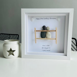 May include: White framed picture with a pebble art design of a couple on a bench. The text reads "Happy Pearl Wedding Anniversary", "Mum & Dad", "26th August 1992", and "30 years married".