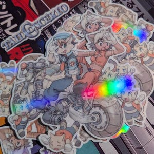 May include: A collection of holographic stickers featuring anime-style characters, including a couple riding a motorcycle. The stickers have a rainbow sheen and include the text "TAIL CONCHKIN". The background includes images of cars and Japanese text.