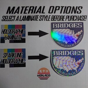 以下が含まれることがあります： ステッカーの素材オプションを示す画像。「素材オプション」と「購入前にラミネートスタイルを選択してください！」というテキストが表示されています。ホログラフィックとスパークリングホログラフィックの2つのラミネートスタイルが示されており、それぞれサンプルステッカーのデザインが施されています。
