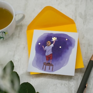 Quadratische Postkarte "DEIN STERNENHIMMEL" - Motiv: Kind greift zu den Sternen - liebevoll illustriert