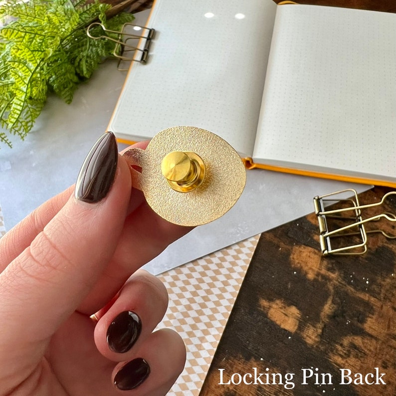 May include: Gold-colored metal pin back with a locking mechanism. The pin back is designed to be used with a pin or brooch.