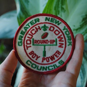May include: A white, red, and green embroidered patch with the text "Greater New York Touch Down Boy Power Councils" and a green football field with the text "Round-Up" on it.
