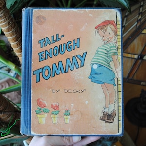May include: A vintage children's book titled "Tall Enough Tommy" by Becky. The cover features a boy in a blue and white striped shirt and blue shorts standing next to a measuring stick.