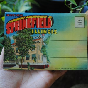 May include: Vintage postcard featuring a colorful illustration of the historic Springfield, Illinois, home of Abraham Lincoln. The postcard has a place for a stamp and a space for writing a message.