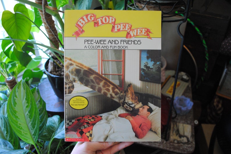 May include: A yellow and red book titled "Big Top Pee-Wee: Pee-Wee and Friends, A Color and Fun Book" with a picture of a giraffe and a man on the cover.