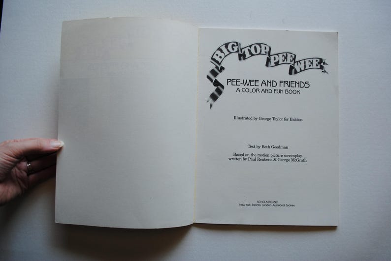 May include: A book cover with a black and white illustration of a circus tent with the words "Big Top Pee-wee" and the title "Pee-wee and Friends: A Color and Fun Book". The book is illustrated by George Taylor for Golden Books and the text is by Beth Goodman.