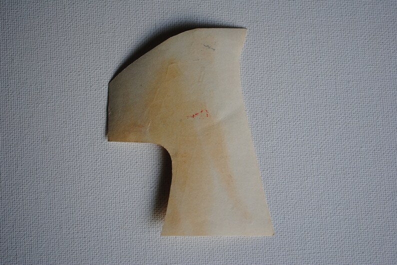 May include: A light brown paper shape resembling the number one. The shape is cut out and has a rough, textured surface.