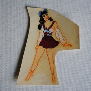 May include: A vintage illustration of a woman wearing a white and red dress with a blue headband. The woman is standing with her legs slightly apart and her arms outstretched. The illustration is on a light brown background.