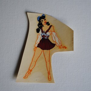 May include: A vintage illustration of a woman wearing a white and red dress with a floral pattern. She has dark hair and is wearing blue bows in her hair. The illustration is on a light brown background.