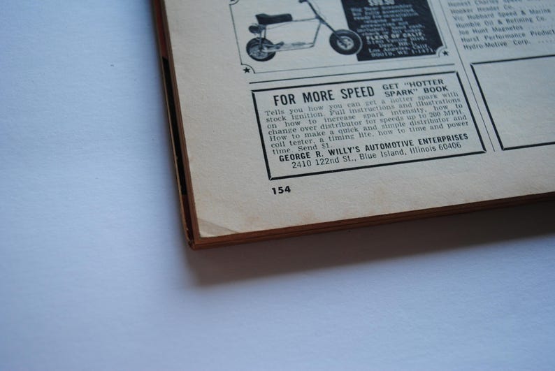 May include: A black and white magazine page with a black and white photo of a mini motorbike. The page has text that reads "FOR MORE SPEED GET HOTTER SPARK BOOK" and includes instructions on how to increase spark intensity, change over a distributor, and how to time and power. The text also includes the name and address of the company, "GEORGE R. WILLY'S AUTOMOTIVE ENTERPRISES, 2410 122nd St., Blue Island, Illinois 60406".