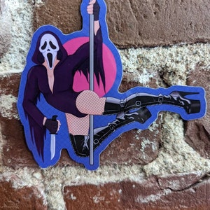 May include: A sticker featuring a cartoon illustration of the Ghostface character from the Scream horror film franchise. The character is depicted in a provocative pose, wearing a black outfit, fishnet stockings, and high-heeled boots, holding a knife and a pole.