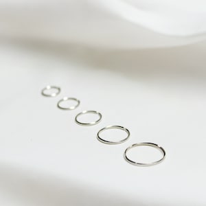 five sterling silver huggie hoops demonstrating various sizes