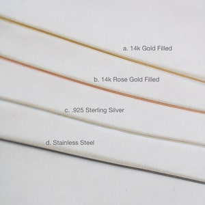 K&ouml;nnte beinhalten: Vier verschiedene Metallstreifen auf wei&szlig;em Hintergrund. Die Streifen sind mit ihrem Metalltyp beschriftet: 14k Gold Filled, 14k Rose Gold Filled, .925 Sterling Silver und Edelstahl.