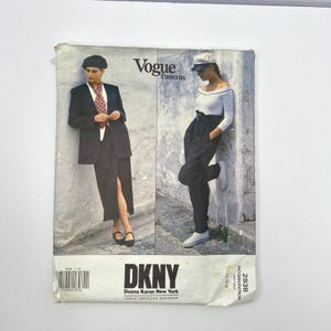May include: A Vogue Patterns sewing pattern envelope for DKNY Donna Karan New York, number 2938, size 14-16-18. The front shows two outfits: a dark blazer with a long skirt and a white long-sleeve top with dark high-waisted trousers and a cap.