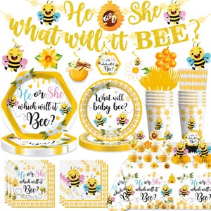 May include: A collection of yellow and white party supplies with a bee theme. Includes plates, cups, napkins, and a banner that reads "He or She, What will it Bee?" with bee and flower decorations. Perfect for a baby shower.