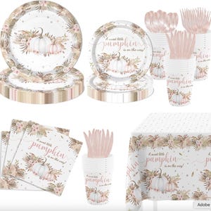 May include: A party supply set featuring white plates, cups, napkins, and a tablecloth decorated with pink pumpkins, dried pampas grass, and the text A sweet little pumpkin is on the way. Includes rose gold plastic forks, spoons, and knives.