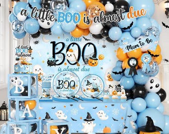 May include: A party decoration set featuring a balloon arch in blue, orange, and black with the text a little BOO is almost due. Includes a backdrop, table cover, plates, and clear boxes spelling BABY with balloons inside, all decorated with ghosts.