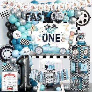 May include: A racing-themed first birthday party decoration set. Includes a banner with baby photos, balloons in blue, black, and silver, and a large number one balloon. The words "Fast One" are featured prominently.