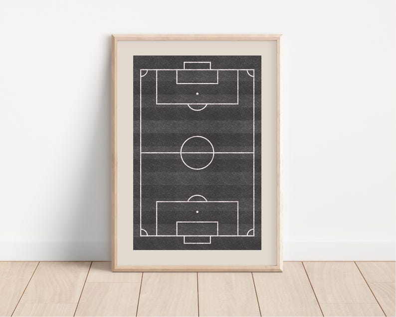 May include: Framed print of a soccer field, featuring a black and gray background with white lines marking the field's boundaries. The print is encased in a light-colored wooden frame, suitable for sports enthusiasts and home decor.