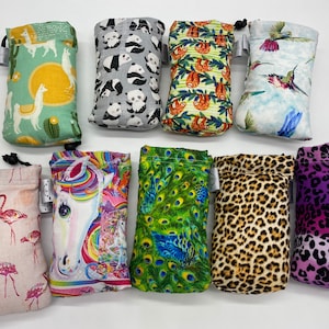 May include: Ten small drawstring bags with various colorful patterns. The patterns include flamingos, a unicorn, peacocks, leopard print, and a purple and pink ombre design.