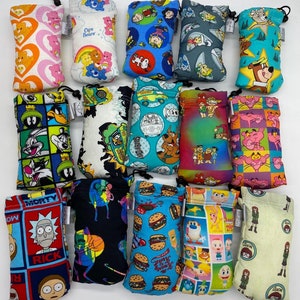 May include: A collection of 15 colorful drawstring pouches with various cartoon characters printed on them. The pouches are made of fabric and have a drawstring closure. The characters include Care Bears, Scooby Doo, Pink Panther, Rick and Morty, and more.