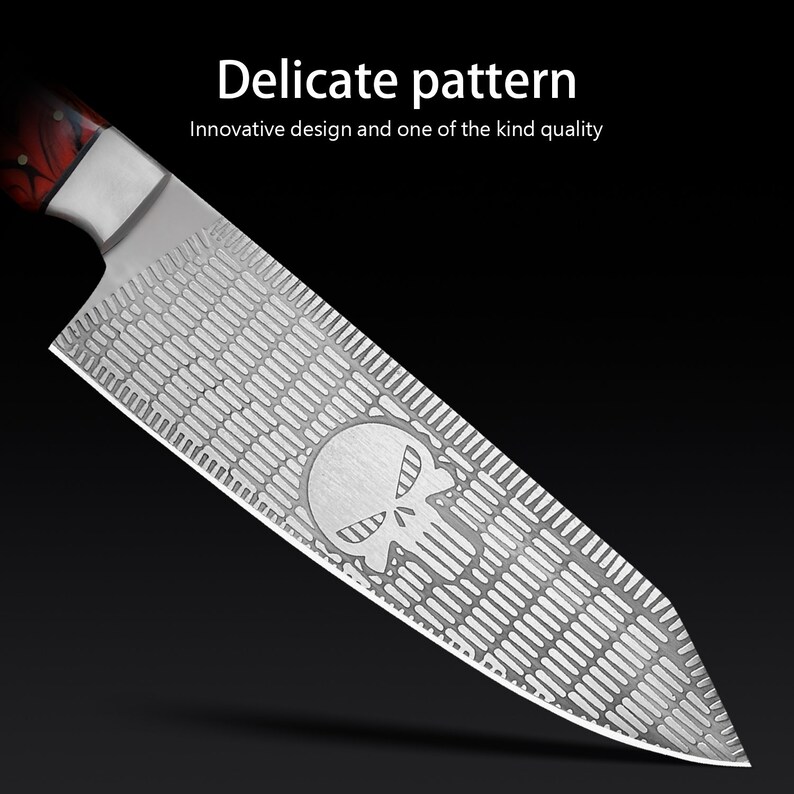 K&ouml;nnte beinhalten: Ein silbernes K&uuml;chenmesser mit einem in die Klinge ge&auml;tzten Totenkopfdesign. Die Klinge hat ein strukturiertes Muster.