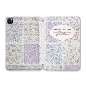 May include: A floral patterned tablet case in a patchwork design. The case features a combination of light blue, lavender, and cream colors. The text "composition book Jackie" is visible on the cover.