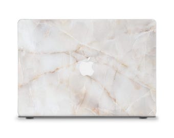 Peut inclure: Coque d'ordinateur portable à motif marbre blanc avec de fines veines beiges. Le logo Apple est au centre. La coque offre protection et style. Le design imite la pierre naturelle.