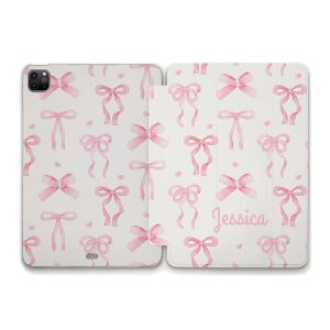Może przedstawiać: Białe etui na tablet z wzorem różowych kokard akwarelowych i małych serc. Imię "Jessica" jest wydrukowane kursywą po prawej stronie. Etui jest otwarte, odsłaniając ekran tabletu.
