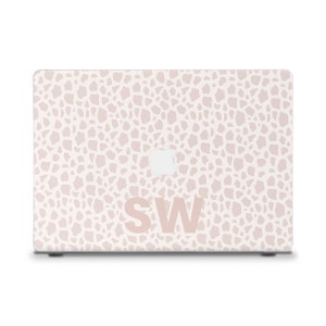 May include: A white laptop with a pink and white abstract pattern and the letters "SW" in pink on the lid.
