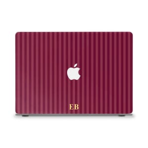 May include: A burgundy laptop case with vertical stripes. The Apple logo is in white, and the initials "EB" are in gold. The case is designed to fit a laptop and provides a protective cover.