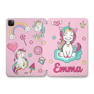 Può includere: Custodia per tablet rosa con un designo di unicorno. La custodia presenta un unicorno con una criniera e una coda arcobaleno, un arcobaleno, un cuore, un lecca-lecca, una ciambella, un'anguria e un diamante. Il retro della custodia presenta un unicorno più grande con una criniera e una coda arcobaleno, una nuvola e il nome "Emma".