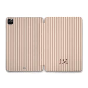 Peut inclure: Étui pour tablette à rayures beiges et marron clair avec les initiales "JM" dans le coin inférieur droit. L'étui est ouvert, révélant le design intérieur et extérieur. L'étui est conçu pour protéger une tablette.