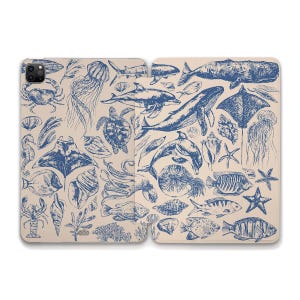 Può includere: Una custodia beige per tablet con un'illustrazione blu a inchiostro di varie creature marine, tra cui balene, delfini, meduse e stelle marine. Il design copre l'intera custodia, offrendo un'estetica coesa a tema oceanico.