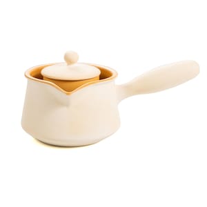 May include: A white ceramic teapot with a light brown lid and a handle. The teapot has a rounded body and a spout.