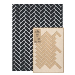Può includere: Uno stencil con motivo a spina di pesce bianco e nero. Lo stencil è realizzato in cartone marrone e riporta la scritta "NAKLEO Seamless Collection".