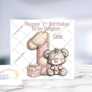 Pu&ograve; includere: Un biglietto d'auguri quadrato con il testo Happy 1st Birthday To my Daughter Cassie. Il design include un grande numero uno cucito in beige e rosa, una piccola scatola regalo e un soffice orsacchiotto grigio che tiene un cuore rosa.